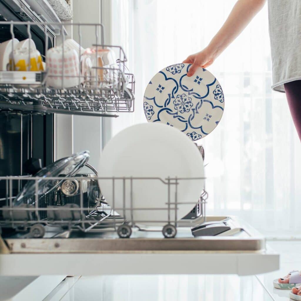 woman placing a sublimated mug in the dishwasher